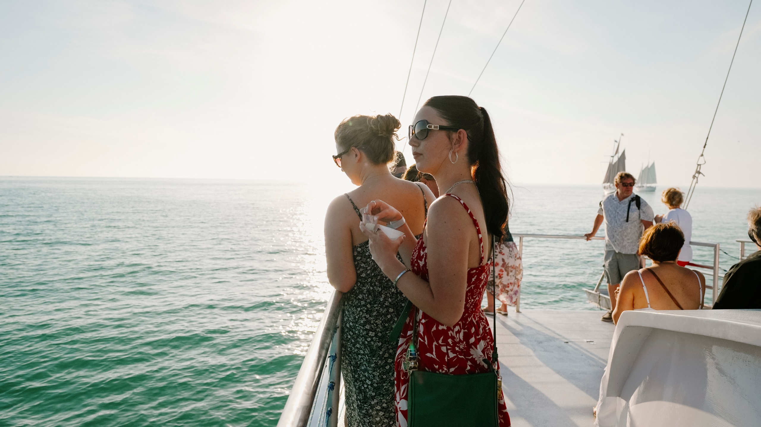 People on a boat enjoying the sea view during sunny weather.