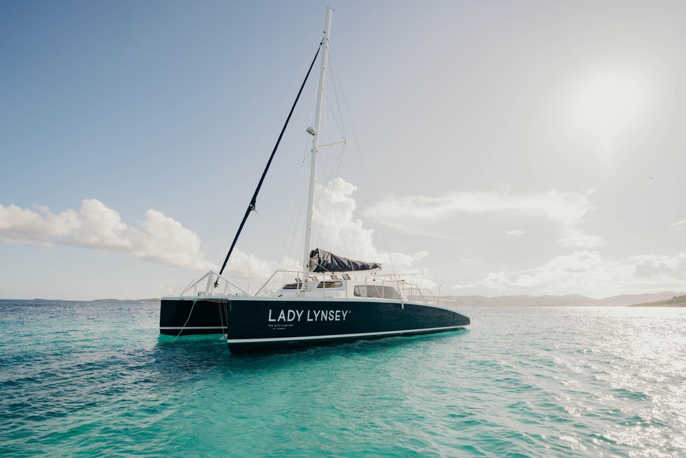 Sailboat named 'Lady Lynsey' on calm blue waters under a clear sky.
